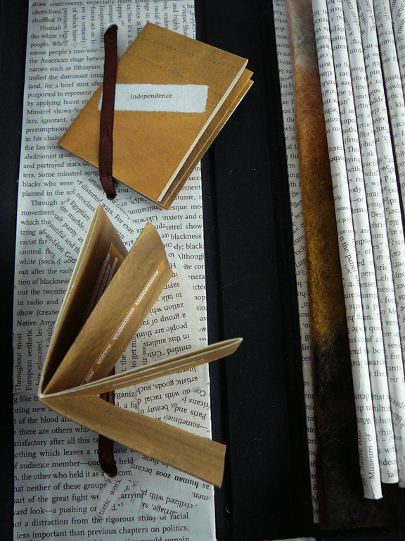 two miniature books and handmade box with text-wrapped dowels