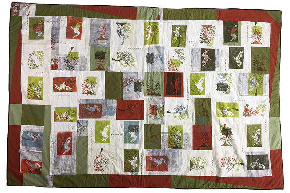 block quilt with various prints of trees and people