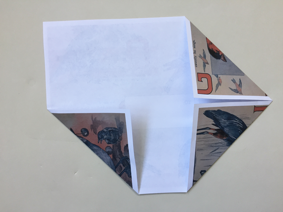 top right corner folded down to align with right crease and both bottom corners still folded up