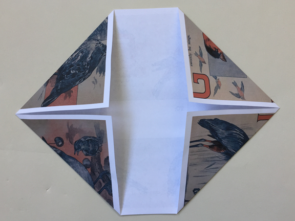 top left corner folded down to align with left crease and three other corners still folded