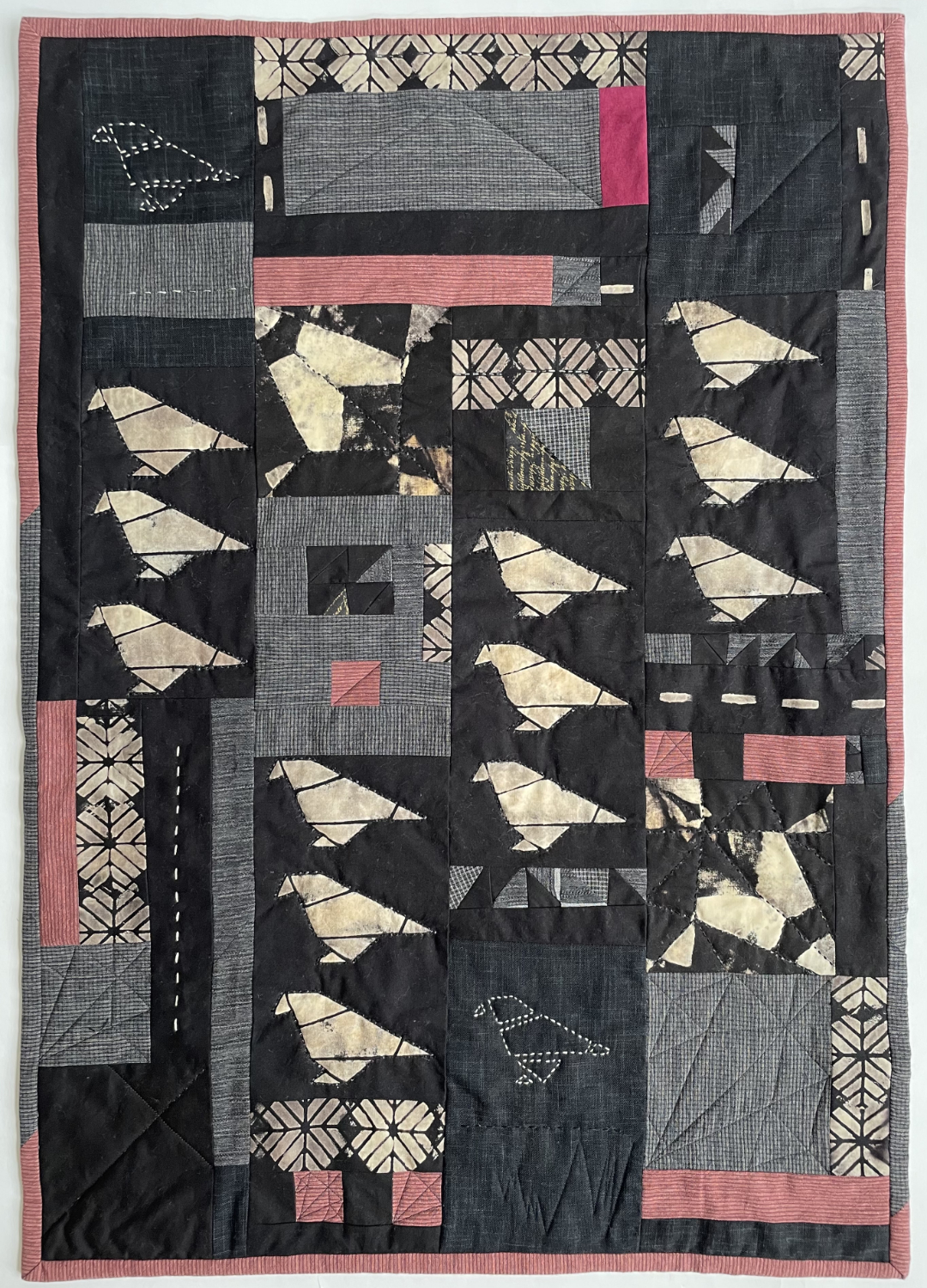 quilt with stitched and stenciled origami bird shapes