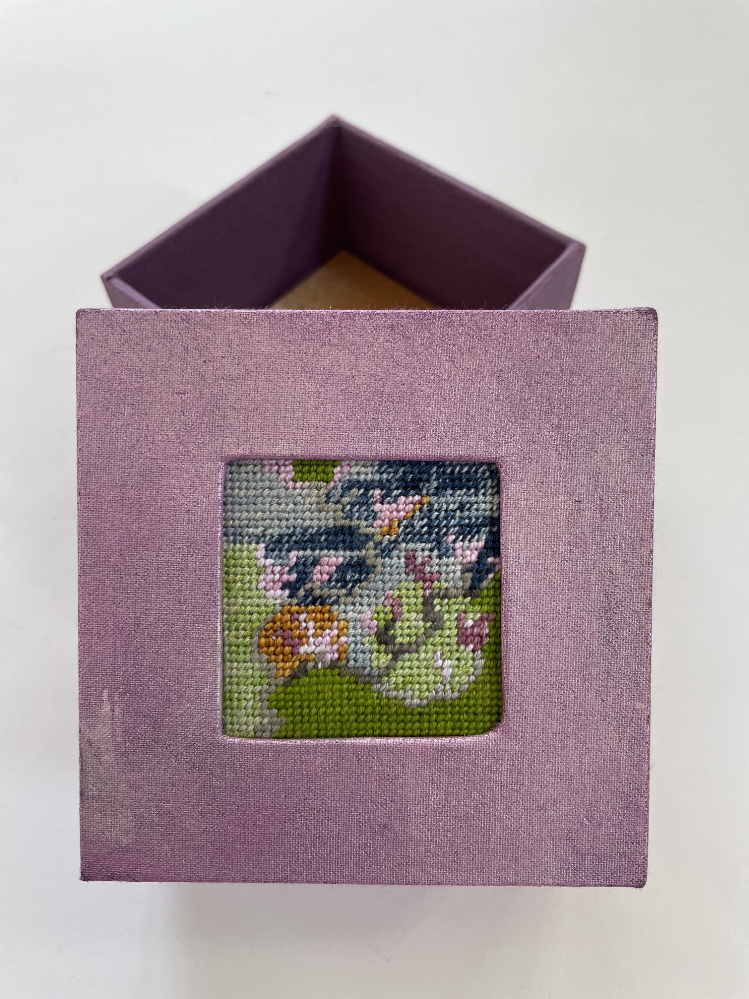 a box with an inset needlepoint of magnolia branches and blooms