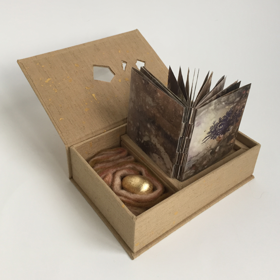 open box with small book and golden egg