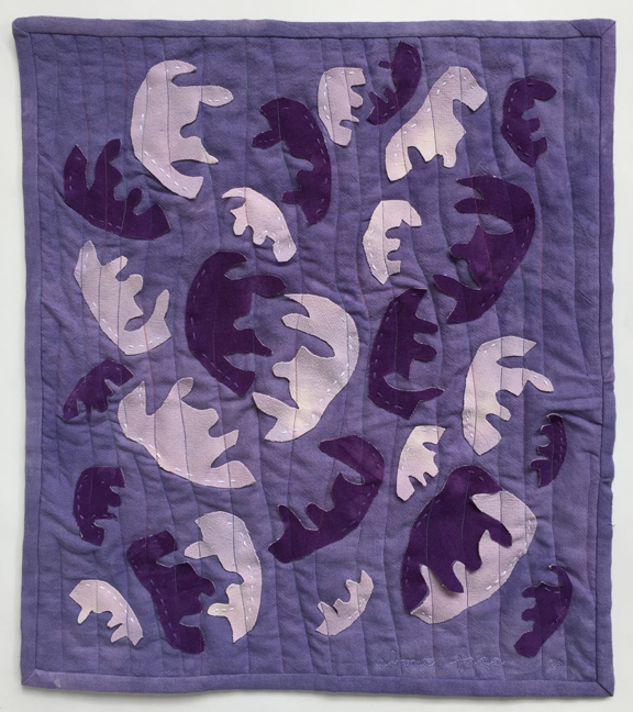 appliqueed faces on quilt with vertical lines sewn across them