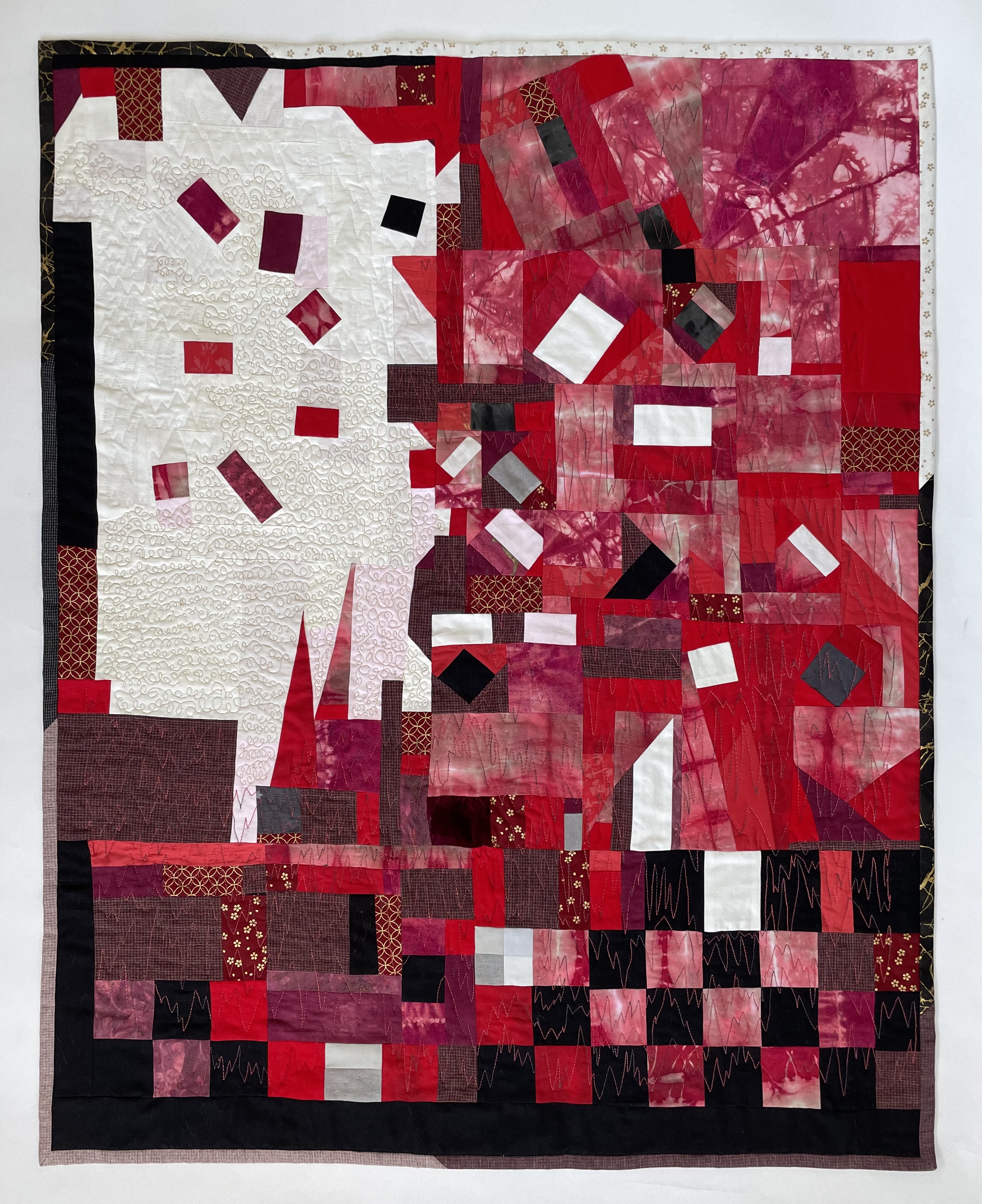 pieced abstract fiery quilt with small shapes askew in a sea of contrasting color