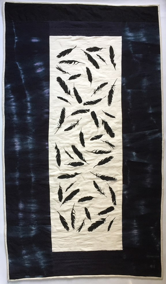 quilt with stenciled crow feathers and night fabric