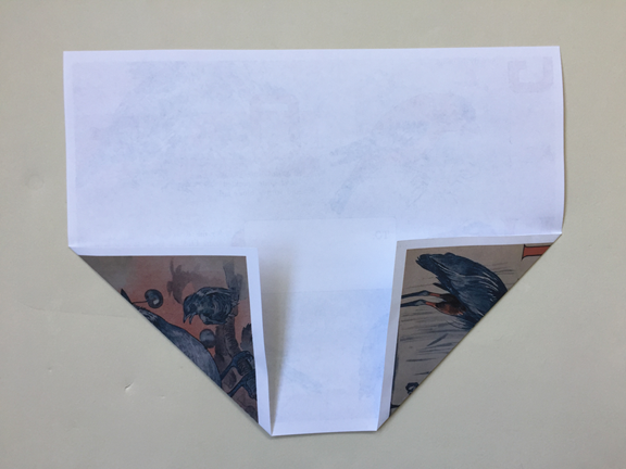bottom left corner folded up to align with left crease and right corner still folded up