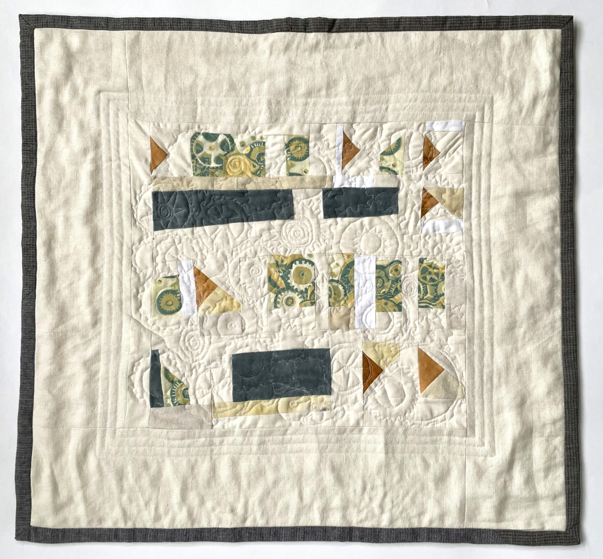 pieced abstract quilt with small shapes including images of gears
