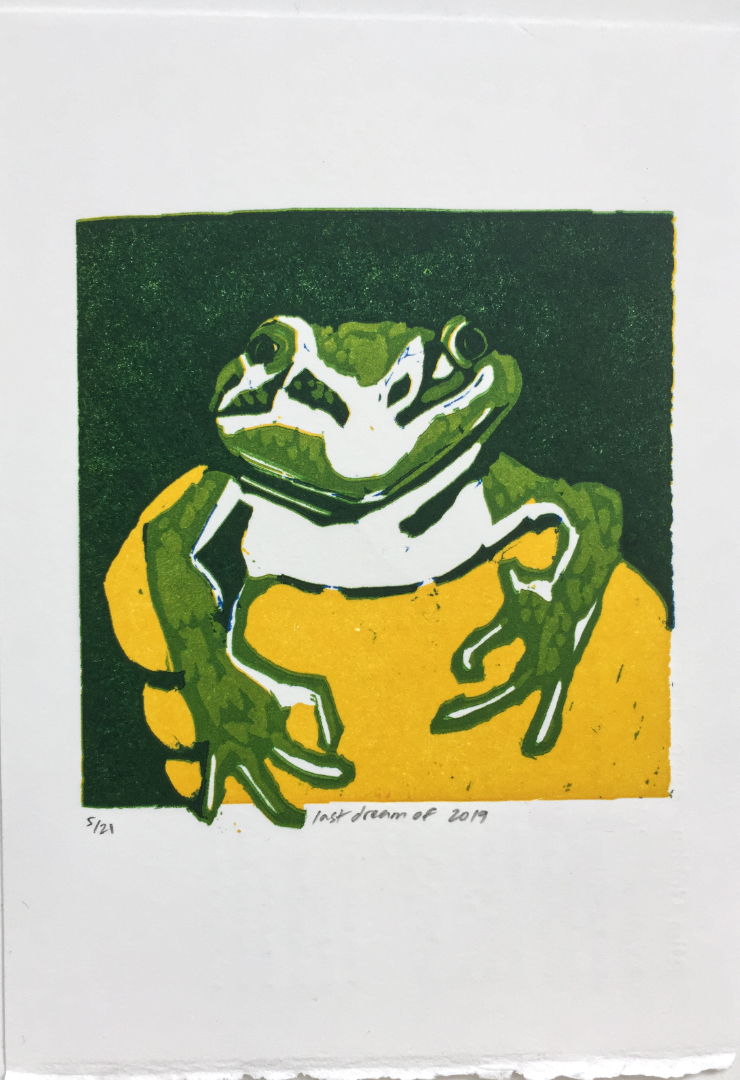 linocut of frog gripped in one hand with just the head and front legs showing