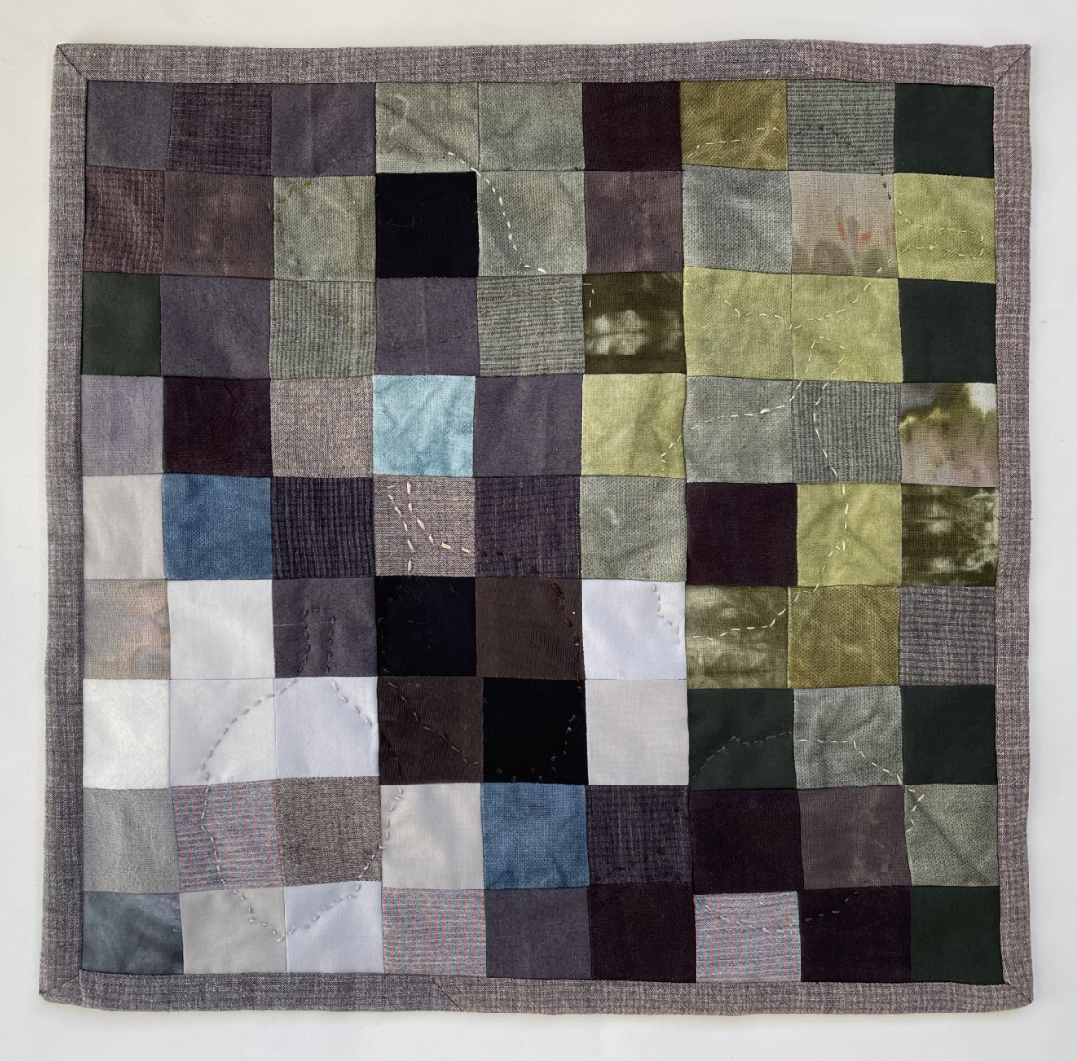 abstract pieced quilt with 9 x 9 squares in oak tree colors and embroidered outlines of oak leaves