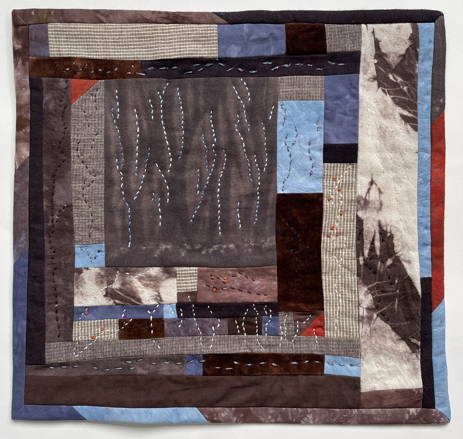 pieced abstract quilt with meandering stitches like tree trunks and branches
